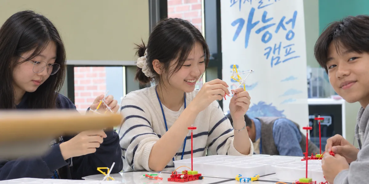 피지컬 AI 가능성 캠프에서 4DFrame 부품으로 구조물을 만들며 웃고 있는 학생들